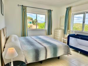 a bedroom with a bed and two windows at Casas do Ramalhete in Luz +193 photos