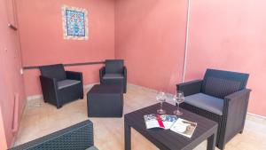 a room with two chairs and a table with wine glasses at Affittacamere Juighissa Leonora in Oristano