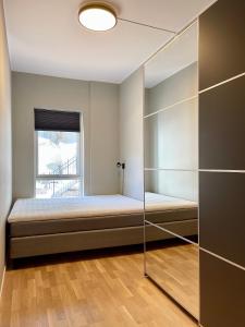 un dormitorio con una cama y una ventana en Brand-new Apartement 2025 Sunny Private Terrace - By the Sea, en Bergen