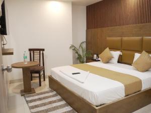 ニューデリーにあるHotel Air City Near Delhi Aiportのベッドルーム(大型ベッド1台、テーブル付)