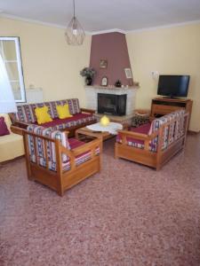 a living room with two couches and a fireplace at Katerina in Ormos Panagias