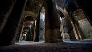 an empty hallway in an old building with arches at Pupatina in Bacoli