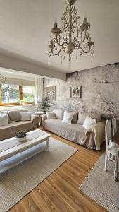 a living room with two beds and a chandelier at Tatrzańska Prowansja SPA&SKI Apartament in Zakopane