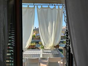 een balkon met een tafel, stoelen en een raam bij MarePia in San Benedetto del Tronto