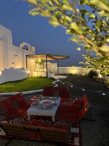 a table and chairs sitting on a patio at zahr albun villa in Al Raka