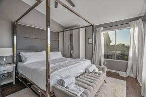 a bedroom with a canopy bed and a chair at Spacious Entire Home 4B & 2.5B in Avondale Arizona in Avondale
