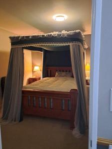 une chambre avec un lit à baldaquin et deux lampes dans l'établissement In Remuera with free street carpark, handy close to cuisine restaurant and public transportation, à Auckland