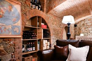 a brick wall with a couch in a wine cellar at Corte Gondina Boutique Hotel in La Morra