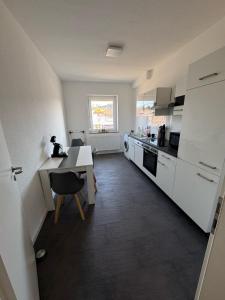 a kitchen with white appliances and a table and chairs at Modernes Zimmer am Campus 3 mit Gemeinschaftsbad in Villingen-Schwenningen