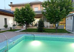 a swimming pool in front of a house at Laurel Hotel in Tashkent