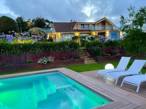 a backyard with a swimming pool and a house at Stylish Host Cantabria- Lujosa villa en Bezana in Santa Cruz de Bezana