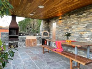 a patio with a wooden bench and a fireplace at Stylish Host Cantabria- Lujosa villa en Bezana in Santa Cruz de Bezana