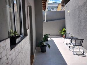 a balcony with chairs and a table and plants at Casa Magalhães Hospedaria in Extrema