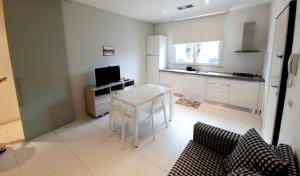 een keuken met een witte tafel en een televisie bij MarePia in San Benedetto del Tronto