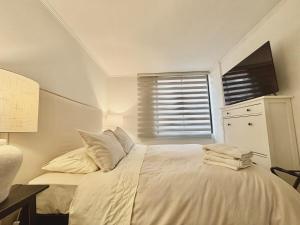 Un dormitorio con una cama blanca y una ventana. en Steps to Costanera Center & Metro, en Santiago