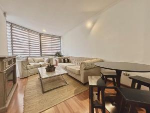 una sala de estar con un sofá y una mesa en Steps to Costanera Center & Metro, en Santiago