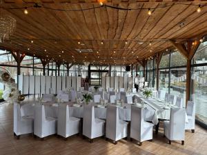 a banquet hall with white tables and white chairs at Przystań Korońa nad jeziorem Raduń in Wałcz