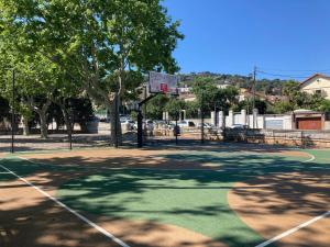 a court with a basketball hoop in a park at La Sensuelle Parenthèse in Sète