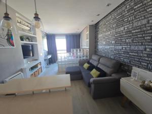 a living room with a couch and a brick wall at Estudio III VISTAS MAR, TREN Y MALAGA in Torremolinos