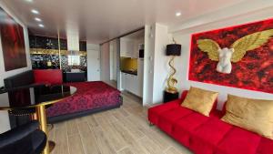 a living room with a red couch and a bedroom at Cap sur le Paradis in Cap d'Agde