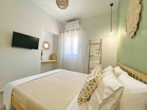 a bedroom with a bed with pillows on it at Bamboo House Syros No1 in Ermoupoli