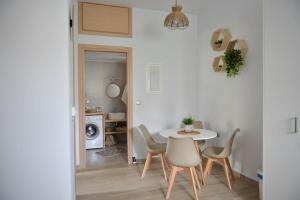 a white dining room with a table and chairs at Bamboo House Syros No1 in Ermoupoli +25 photos