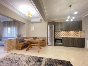 a living room with a table and a kitchen at Poseidon Horizon in Leptokarya