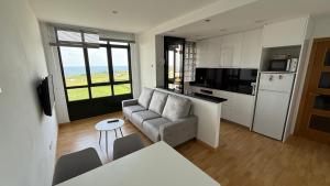 a living room with a couch and a kitchen at A Orillas de Llas in Foz