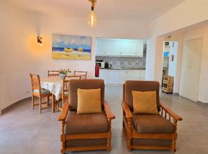 een keuken en eetkamer met een tafel en stoelen bij Villa Alprochinhos in Porches