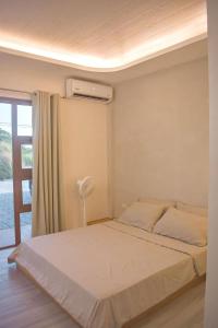 a bedroom with a bed and a air conditioner at Minimalist Home 5 mins to Calle Crisologo Vigan in San Vincente