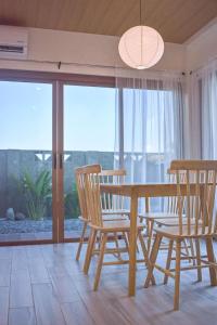 a dining room with a table and chairs and a window at Minimalist Home 5 mins to Calle Crisologo Vigan in San Vincente
