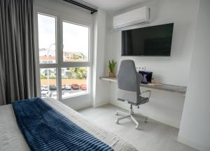 una camera da letto con scrivania, sedia e finestra di Costa Adeje Sunset Ocean City Mountain View 15 By-Tenerife365 ad Adeje