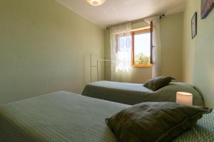 two beds in a small room with a window at L'Olivo Maritato in Siena