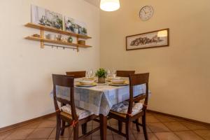 a dining room with a table with chairs and a clock at L'Olivo Maritato in Siena +19 photos