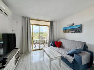 Una sala de estar con un sofá y un televisor. en Apartsalou Masia, en Salou