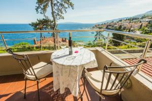 a table on a balcony with a view of the ocean at Apartments Villa Dinka in Opatija