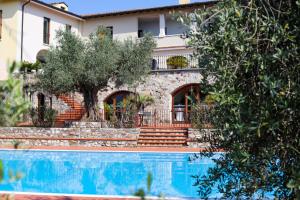 a house with a swimming pool in front of a building at San Rocco Relais in Soiano del Lago