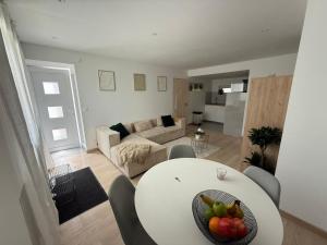 ein Wohnzimmer mit einem weißen Tisch, auf dem Obst lag in der Unterkunft Vertu'Ose avec jacuzzi in Morbier
