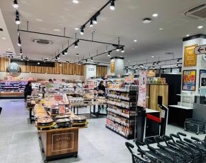 a grocery store aisle with chairs in a store at Sky Home新宿 in Tokyo
