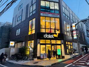 a building with an adidas store on a city street at Sky Home新宿 in Tokyo