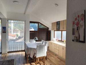 a kitchen and dining room with a table and chairs at White Apartment in Prizren