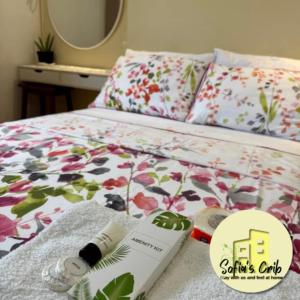 a bed with a flower patterned bedspread and a book on it at Sofia's Crib Mesaverte Garden Residences in Cagayan de Oro