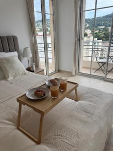 a room with a table with a plate of food on a bed at Magnifique T2 avec grande terrasse in Le Cannet