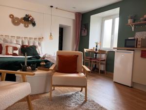 a living room with a couch and a refrigerator at L'écrin de la villa des roses in Pontmain