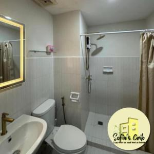 a bathroom with a toilet and a sink and a shower at Sofia's Crib Mesaverte Garden Residences in Cagayan de Oro