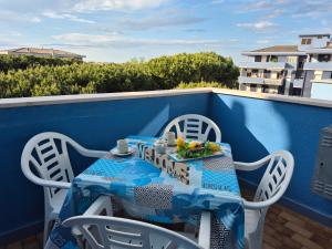 a table and chairs on a balcony with a blue wall at Temporary Home Silvi 5 in Silvi Marina