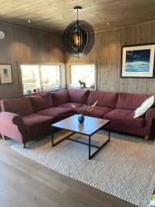 a living room with a red couch and a coffee table at Cabin at Norefjell! Perfect for families with children in Runn