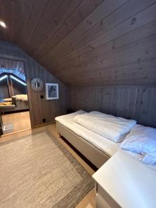 a bedroom with two beds in a wooden room at Cabin at Norefjell! Perfect for families with children in Runn