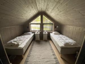 two beds in a room with a large window at Cabin at Norefjell! Perfect for families with children in Runn