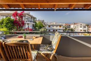 a balcony with a wooden table and chairs on a balcony at The travellers's house in Chalkida